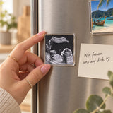 Hand placing an ultrasound photo magnet on the fridge